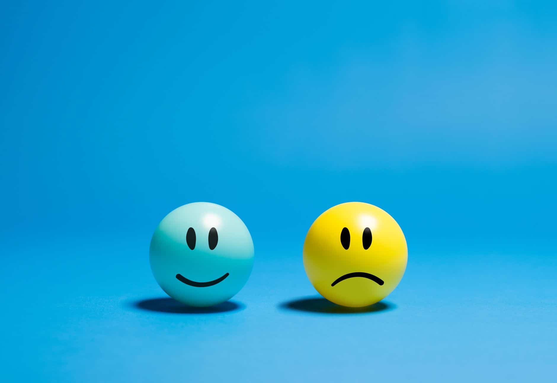 contrasting emotions on smiley balls
